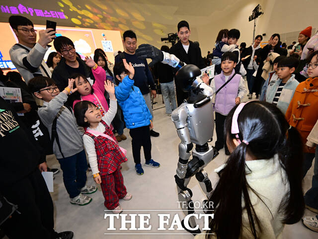 1일 서울 동대문디자인플라자(DDP)에서 열린 '서울AI페스티벌 2026'에 참가한 어린이들이 휴머노이드 로봇 G1과 손인사를 하고 있다.