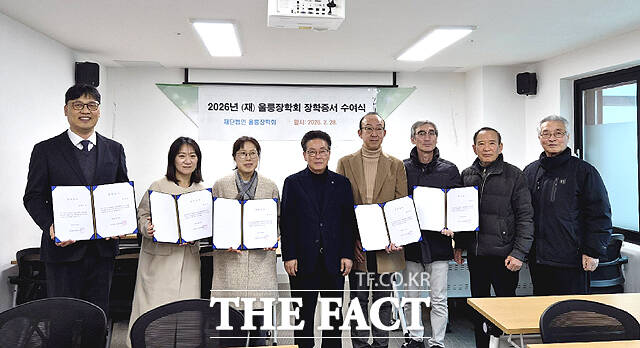 김병수 울릉장학회 이사장(왼쪽 네번째)이 장학생 학부모에게 장학증서를 수여한뒤 기념사진을 찍고 있다. /울릉장학회