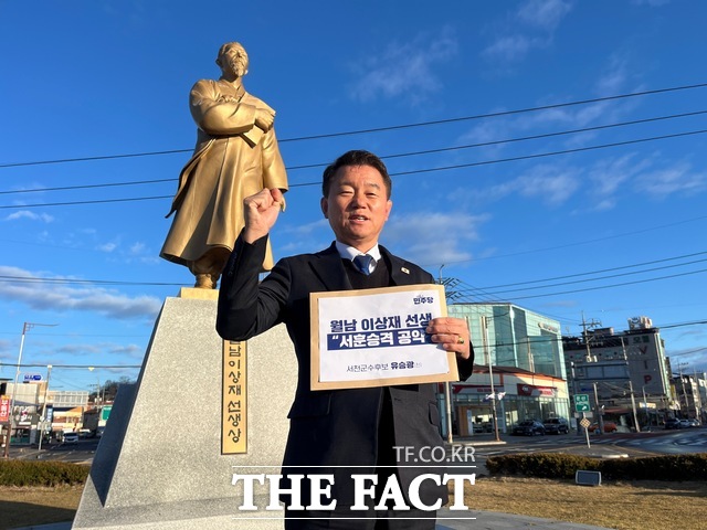 유승광 서천군수 예비후보가 3일 서천군 월남 이상재 선생 동상 앞에서 서훈 상향 공약이 담긴 피켓을 들고 있다. /유승광 예비후보