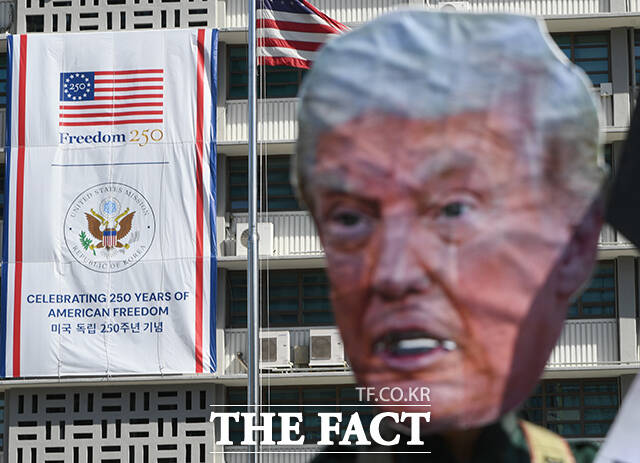 트럼프 대통령 가면을 쓴 기자회견 참가자가 퍼포먼스를 하고 있다.