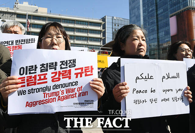 기자회견 참가자들이 이란 침략을 규탄하는 손피켓을 들고 있다.