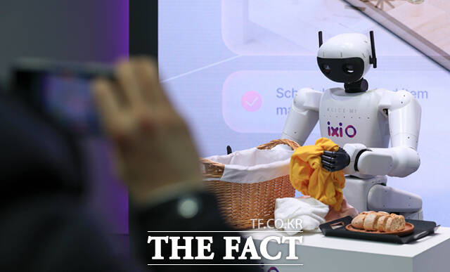 LG유플러스 부스에서 AI에이전트 ‘익시오’가 그린 미래를 시연하는 로봇이 빨래를 바구니에 넣고 있다. /바르셀로나=사진공동취재단