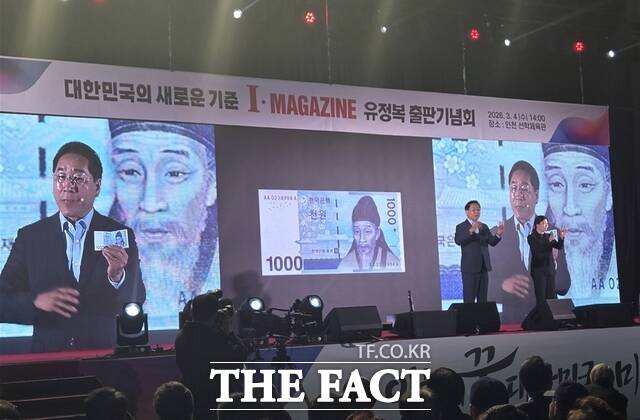 유정복 인천시장이 4일 출판기념회에서 천 원 지폐 한 장을 꺼내 천원주택, 천원택배, i-바다패스 등 천원시리즈 정책을 소개하고 있다. /김재경 기자