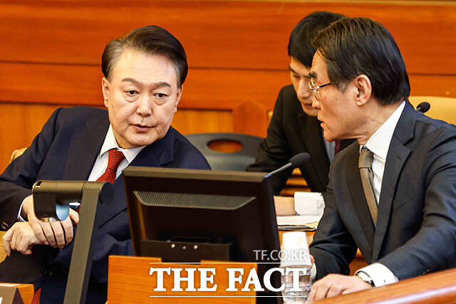 윤석열 전 대통령이 지난해 2월 11일 서울 종로구 헌법재판소에서 열린 '윤석열 대통령 탄핵심판 7차 변론'에 출석해 배보윤 변호사와 의견을 나누고 있다./사진공동취재단