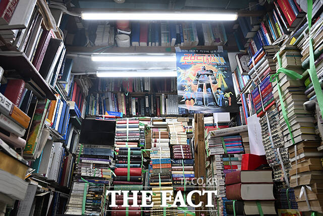채 씨의 서점에 로보트태권브이 포스터와 함께 책들이 쌓여있다.