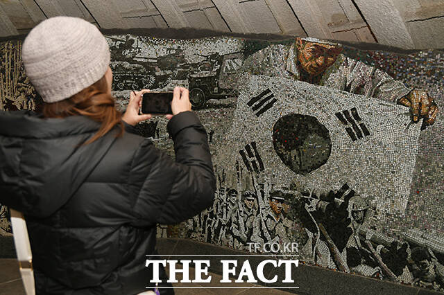 한 외국인 관광객이 6일 오전 서울 용산구 전쟁기념관 형제의 상 내부에 조성된 태극기를 촬영하고 있다.
