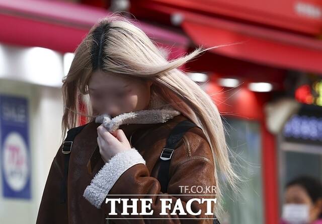 꽃샘추위가 찾아온 지난 7일 서울 명동거리에서 한 시민이 추위를 피하며 이동하고 있다. /뉴시스