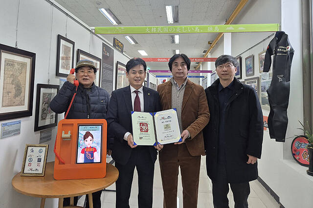 업무협약 체결 후 독도는 우리땅 가수 정광태(왼쪽 첫 번째)씨가 대화형 AI 캐릭터 솔루션·키오스크를 들어보이고 있다. /독도사랑회