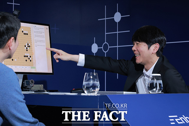 이세돌 9단이 바둑 모델을 보며 미소를 짓고 있다.