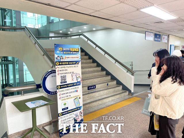 수원시 공직자들이 직원복지 통합 플랫폼, 인공지능 챗봇 등을 안내하는 홍보물을 보고 있다. /수원시