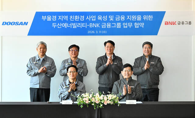 BNK금융지주와 두산에너빌리티는 11일 경남 창원 두산에너빌리티 본사에서 빈대인 BNK금융지주 회장(앞줄 오른쪽)과 박상현 두산에너빌리티 대표이사(앞줄 왼쪽)가 참석한 가운데 친환경 에너지 사업 협력을 위한 업무협약을 체결했다. /BNK금융