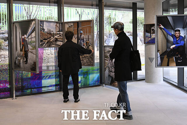 전시 참여 작가들이 작품을 바라보고 있다.