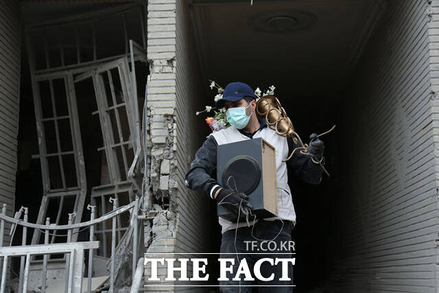 이란 시민이 12일(현지시간) 테헤란의 손상된 건물에서 생필품을 찾고 있다. /테헤란=신화.뉴시스