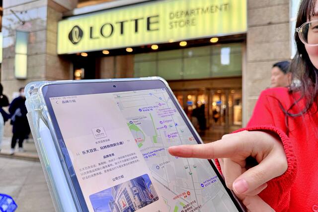 서울 중구 소공동에 위치한 롯데백화점 본점 앞에서 모델이 고덕지도 앱을 가리키고 있다. /롯데백화점