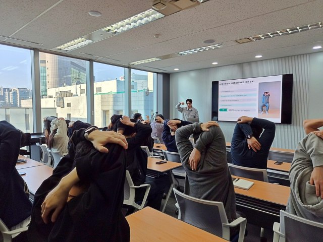 동국시스템즈 임직원들이 근골격 케어 프로그램에 참석해 전문 강사의 지도에 따라 어깨 스트레칭 실습을 진행하는 모습. /동국홀딩스