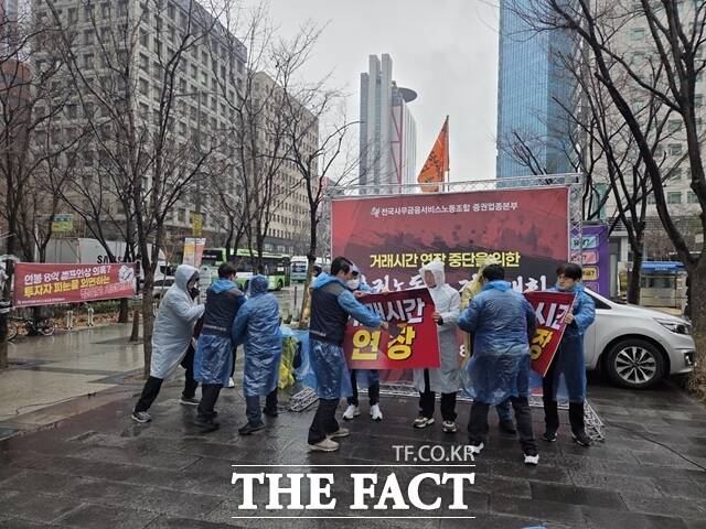 전국사무금융서비스노동조합 증권업종본부(사무금융노조)가 18일 서울 영등포구 한국거래소 서울사옥 앞에서 '증권 거래시간 연장 중단 증권노동자 결의대회'를 열고 '거래시간 연장'이 적힌 피켓을 부수는 퍼포먼스를 하고 있다. /장혜승 기자