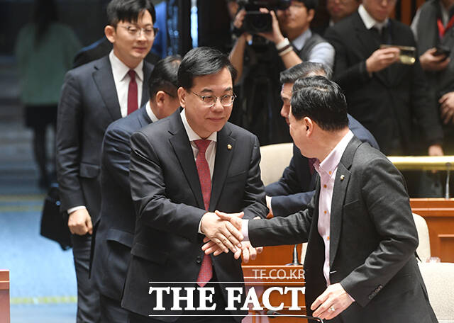 송언석 국민의힘 원내대표(왼쪽)가 의총에 참석하며 동료 의원들과 악수를 나누고 있다.