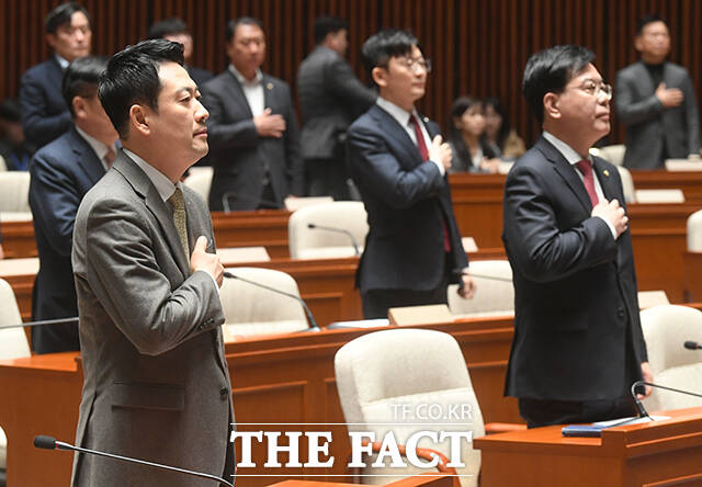 장동혁 국민의힘 대표(왼쪽)가 의총 시작에 앞서 국기에 대한 경례를 하고 있다.