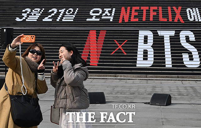 외국인 관광객들이 3월 11일 서울 종로구 세종문화회관 중앙계단에 설치된 보이그룹 방탄소년단의 컴백 랩핑 앞에서 기념촬영을 하고 있다. /김성렬 기자