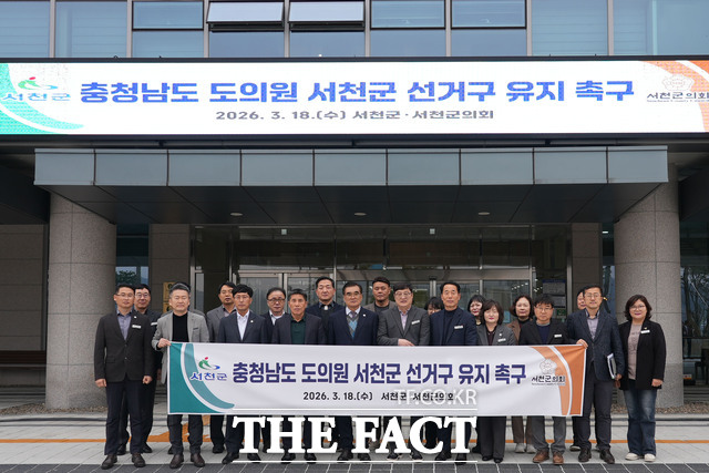 충남 서천군 공직자들이 광역의원 정수 유지 촉구 서명운동 현수막을 들고 있다. /서천군