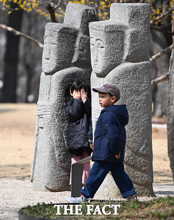 어린 아이가 눈을 가리고 꼭 숨어 있습니다.