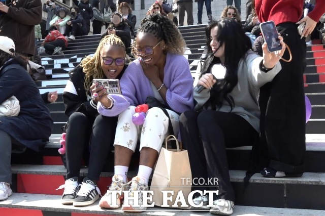 방탄소년단(BTS) 컴백 공연을 하루 앞둔 20일, 서울 광화문광장에서 외국인 관광객들이 신곡 ‘SWIM’ 뮤직비디오를 시청하고 있다. /광화문=김민지 기자