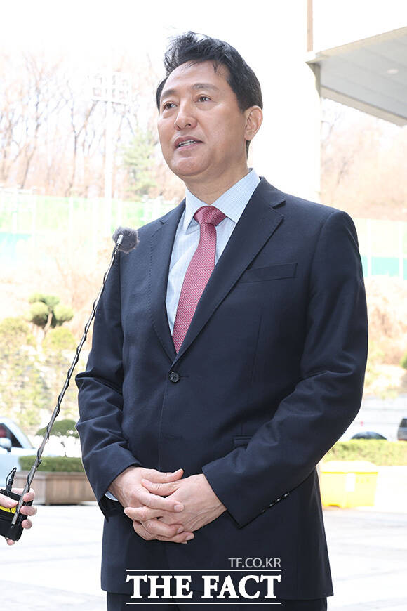 오세훈 시장이 바람에 흩날린 머리를 정리하고 있다.