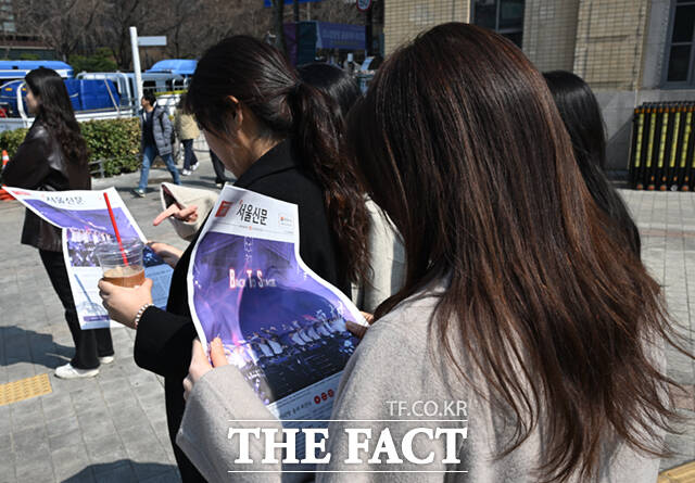 방탄소년단(BTS)의 서울 광화문광장 공연 하루 전인 20일 오후 서울 광화문 일대에서 시민들이 한 신문사가 발행한 BTS 관련 호외를 살펴보고 있다. /이새롬 기자