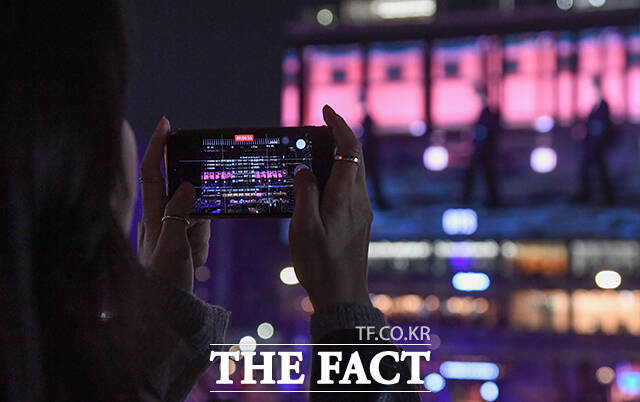 그룹 방탄소년단(BTS) 컴백 공연을 하루 앞둔 20일 오후 시민들이 서울 종로구 광화문광장 일대 건물 전광판에 상영되는 'BTS 경복궁 스페셜 필름'을 바라보고 있다. /박상민 기자