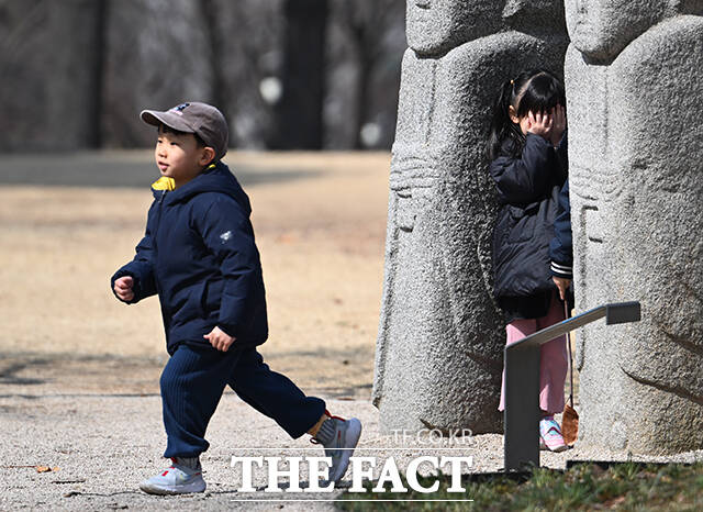 어린 아이가 눈을 가리고 꼭 숨어 있습니다.