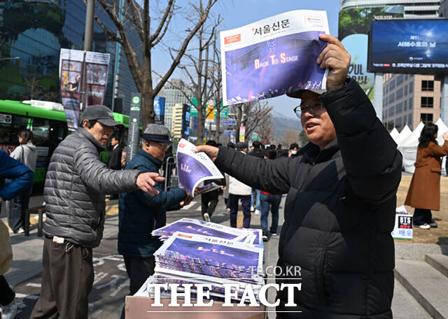 방탄소년단(BTS)의 서울 광화문광장 공연 하루 전인 20일 오후 서울 광화문 일대에서 시민들이 한 신문사가 발행한 BTS 관련 호외를 살펴보고 있다. /이새롬 기자