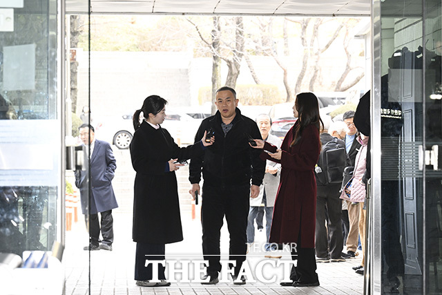 법원 경비원이 명태균 씨와 오세훈 서울시장의 지지자의 언쟁을 말리고 있다.