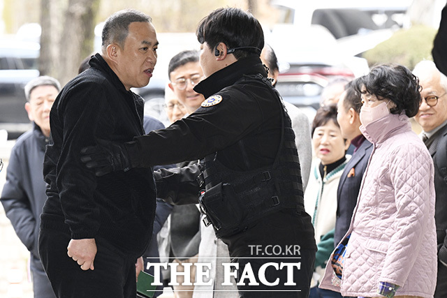 법원 경비원이 명태균 씨와 오세훈 서울시장의 지지자의 언쟁을 말리고 있다.