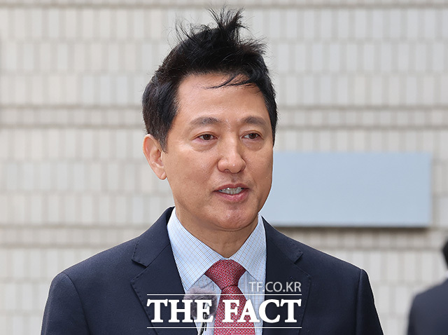 오세훈 시장이 바람에 흩날린 머리를 정리하고 있다.