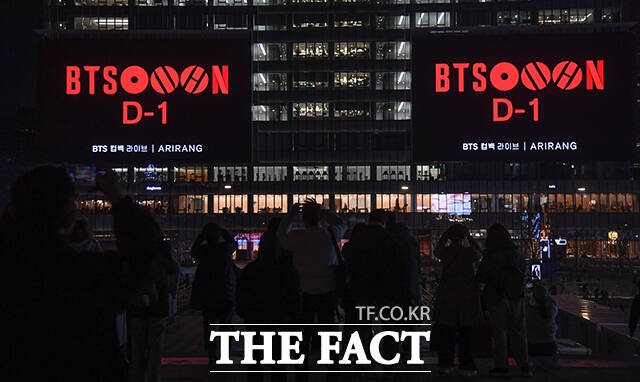 그룹 방탄소년단(BTS) 컴백 공연을 하루 앞둔 20일 오후 시민들이 서울 종로구 광화문광장 일대 건물 전광판에 상영되는 'BTS 경복궁 스페셜 필름'을 바라보고 있다. /박상민 기자