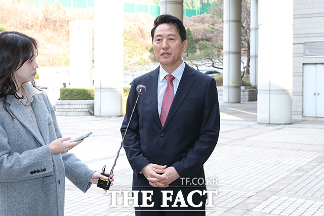 오세훈 시장이 바람에 흩날린 머리를 정리하고 있다.