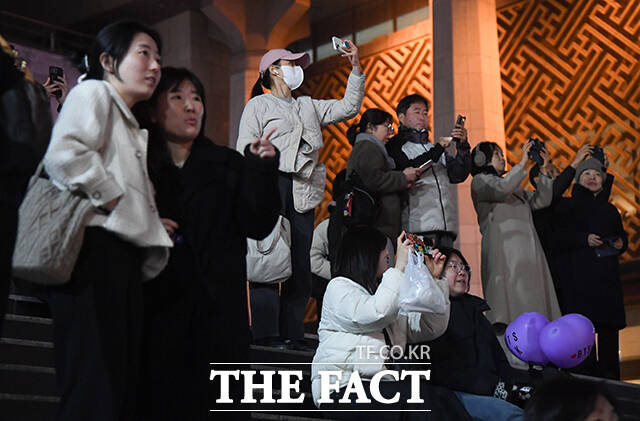 그룹 방탄소년단(BTS) 컴백 공연을 하루 앞둔 20일 오후 시민들이 서울 종로구 광화문광장 일대 건물 전광판에 상영되는 'BTS 경복궁 스페셜 필름'을 바라보고 있다. /박상민 기자