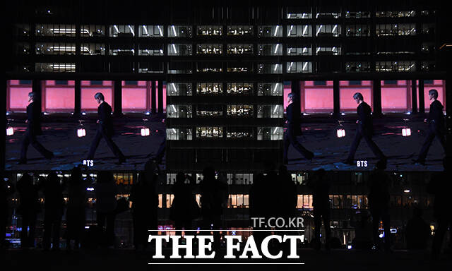 그룹 방탄소년단(BTS) 컴백 공연을 하루 앞둔 20일 오후 시민들이 서울 종로구 광화문광장 일대 건물 전광판에 상영되는 'BTS 경복궁 스페셜 필름'을 바라보고 있다. /박상민 기자
