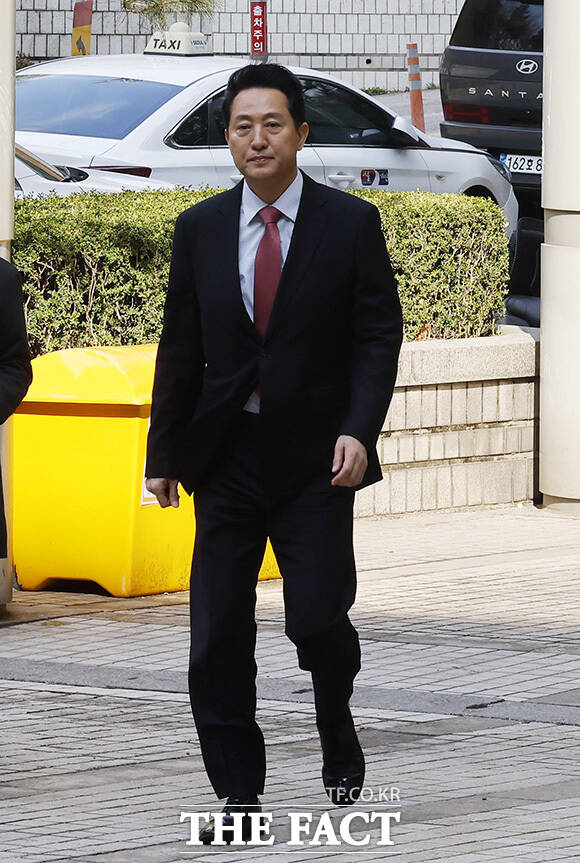 오세훈 시장이 바람에 흩날린 머리를 정리하고 있다.