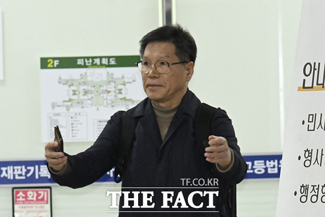 김병헌 대표가 법원 출입구 방향을 가리키고 있다.