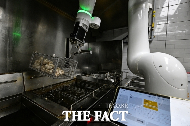 지난 6일 오후 서울 강동구 교촌치킨 고덕비즈밸리점에서 협동조리로봇이 치킨을 조리하고 있다. /서예원 기자
