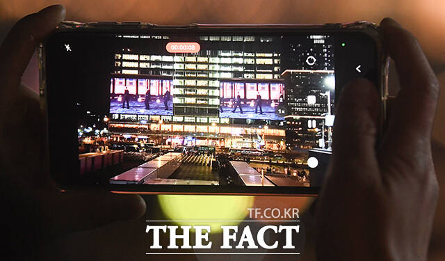 그룹 방탄소년단(BTS) 컴백 공연을 하루 앞둔 20일 오후 시민들이 서울 종로구 광화문광장 일대 건물 전광판에 상영되는 'BTS 경복궁 스페셜 필름'을 바라보고 있다. /박상민 기자