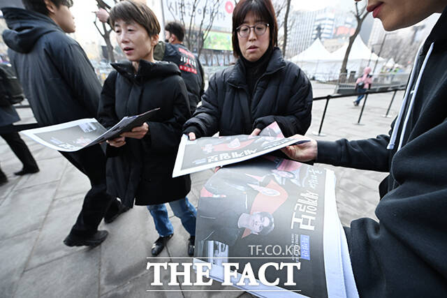 그룹 방탄소년단(BTS)의 컴백 라이브를 앞둔 21일 오후 서울 종로구 광화문 일대에서 외국인 관광객이 한 신문사가 발행한 BTS 관련 특별판을 들고 기념촬영을 하고 있다. /박헌우 기자