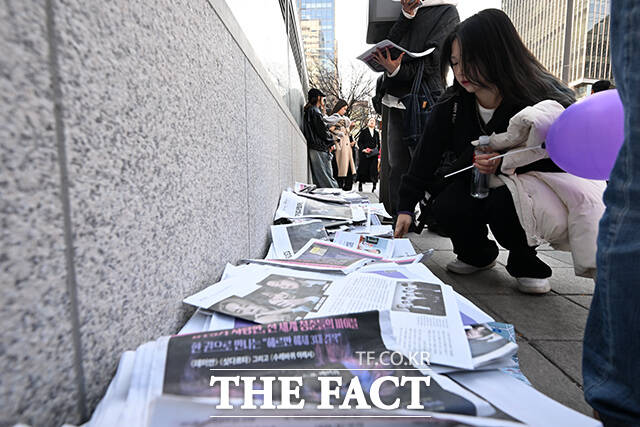 ‘BTS 컴백 라이브: 아리랑’ 개최 당일인 21일 오후 서울 중구 시청역 인근에서 외국인 관광객들이 신문사에서 발행한 BTS 관련 특별판을 들고 기념촬영을 하고 있다. /김성렬 기자