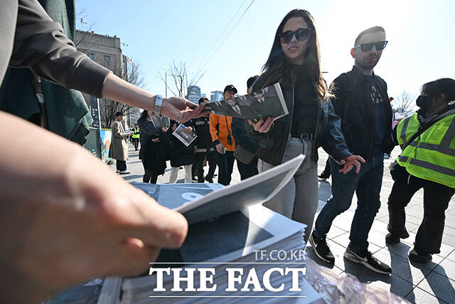 ‘BTS 컴백 라이브: 아리랑’ 개최 당일인 21일 오후 서울 중구 시청역 인근에서 외국인 관광객들이 신문사에서 발행한 BTS 관련 특별판을 들고 기념촬영을 하고 있다. /김성렬 기자