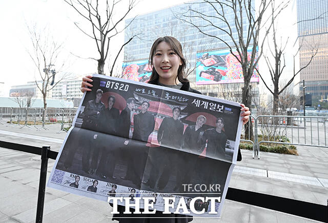 그룹 방탄소년단(BTS)의 컴백 라이브를 앞둔 21일 오후 서울 종로구 광화문 일대에서 외국인 관광객이 한 신문사가 발행한 BTS 관련 특별판을 들고 기념촬영을 하고 있다. /박헌우 기자