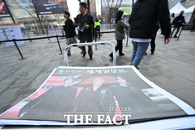 그룹 방탄소년단(BTS)의 컴백 라이브를 앞둔 21일 오후 서울 종로구 광화문 일대에서 외국인 관광객이 한 신문사가 발행한 BTS 관련 특별판을 들고 기념촬영을 하고 있다. /박헌우 기자