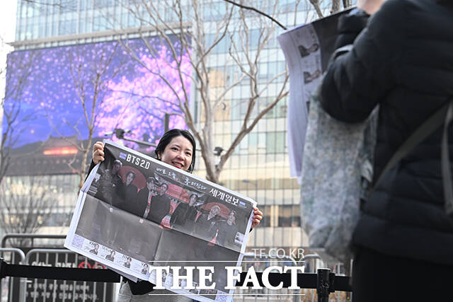 그룹 방탄소년단(BTS)의 컴백 라이브를 앞둔 21일 오후 서울 종로구 광화문 일대에서 외국인 관광객이 한 신문사가 발행한 BTS 관련 특별판을 들고 기념촬영을 하고 있다. /박헌우 기자