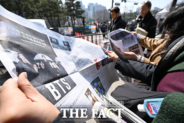 ‘BTS 컴백 라이브: 아리랑’ 개최 당일인 21일 오후 서울 중구 시청역 인근에서 외국인 관광객들이 신문사에서 발행한 BTS 관련 특별판을 들고 기념촬영을 하고 있다. /김성렬 기자