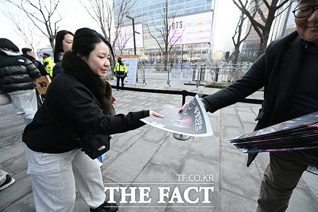 그룹 방탄소년단(BTS)의 컴백 라이브를 앞둔 21일 오후 서울 종로구 광화문 일대에서 외국인 관광객이 한 신문사가 발행한 BTS 관련 특별판을 들고 기념촬영을 하고 있다. /박헌우 기자